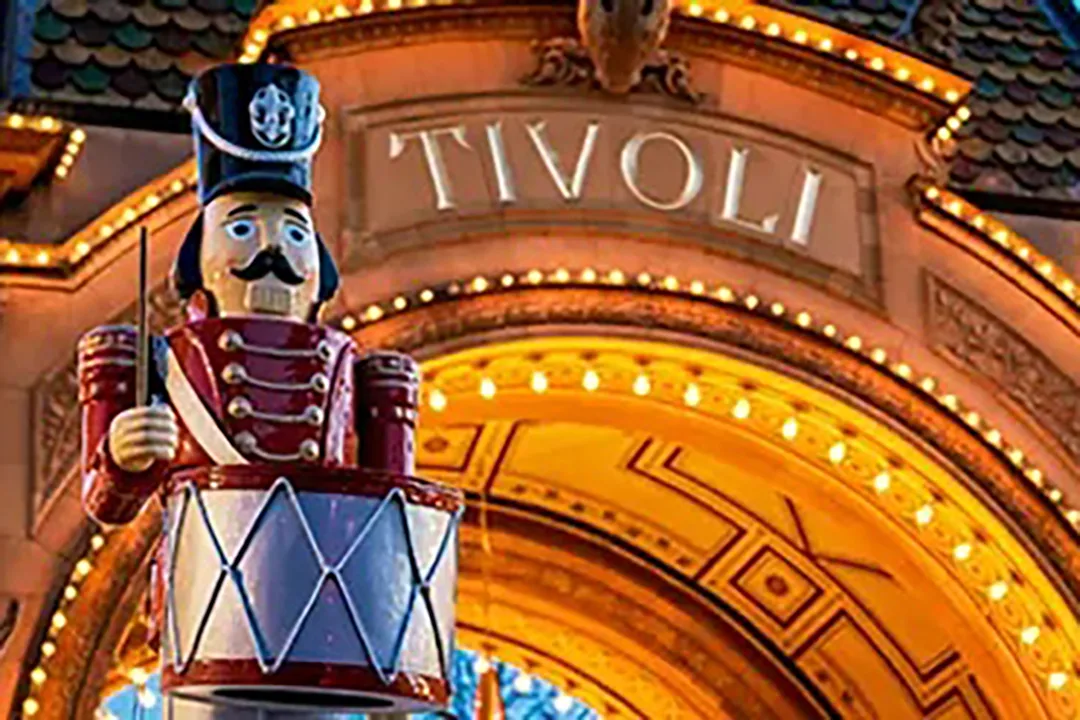 En staty av en leksakssoldat med en trumma står framför en starkt upplyst, utsmyckad entrébåge med ordet TIVOLI.